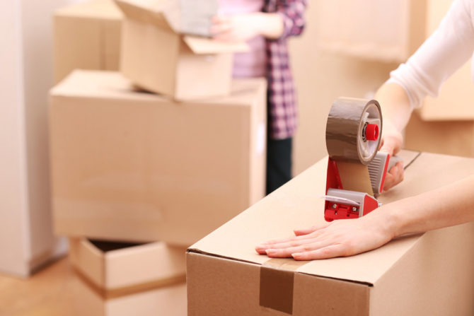 Using packing tape to close a box before moving day