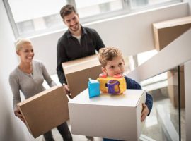 A family carrying boxes to their new home